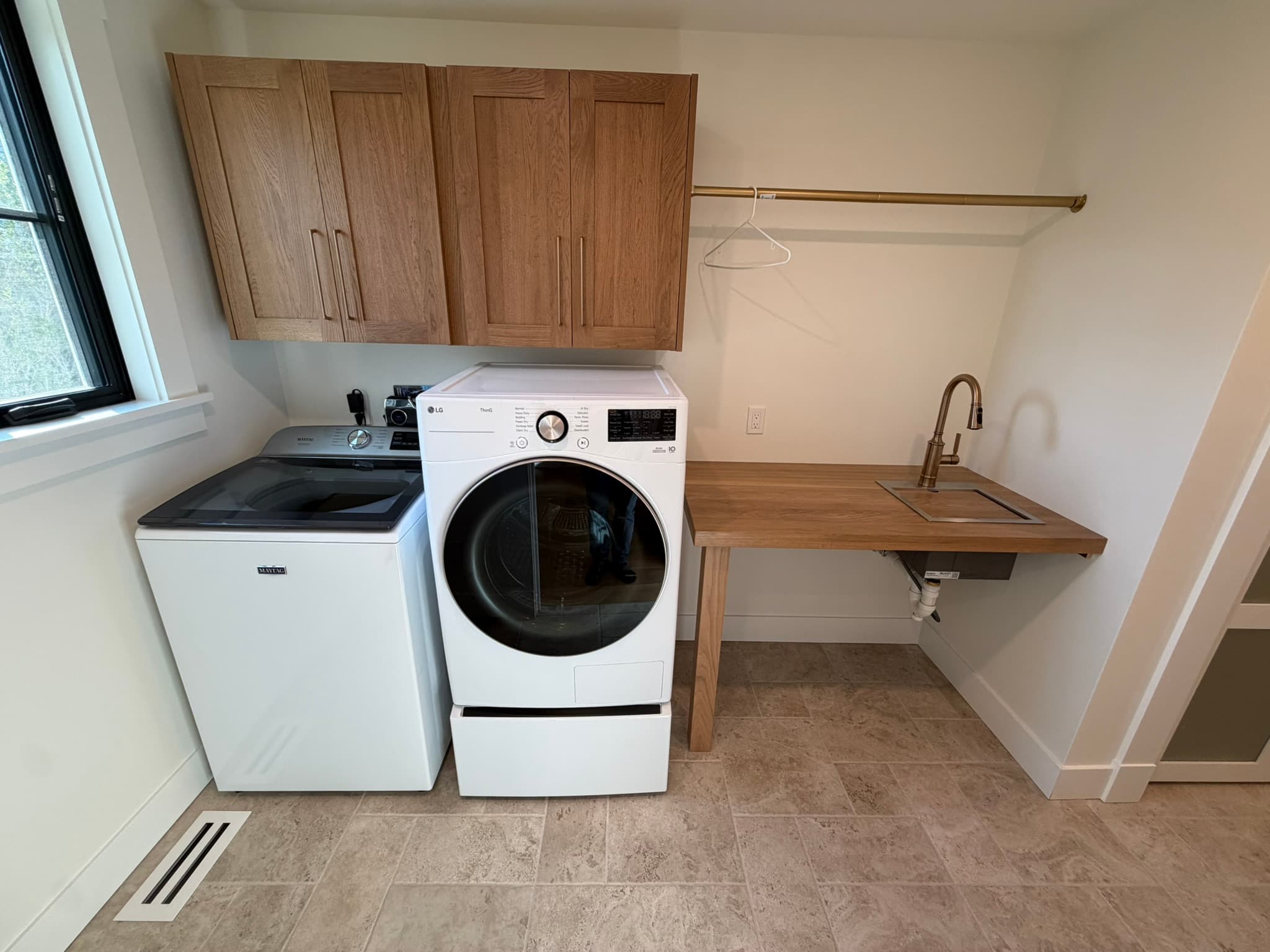 Laundry room with a full-size washer and dryer and a folding counter