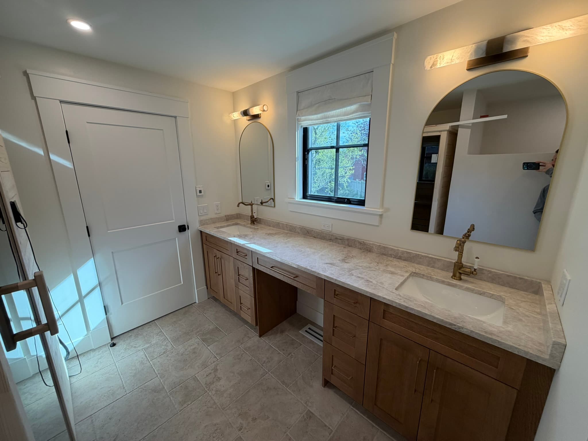 Primary bath with a double vanity, marble counter, and framed mirrors