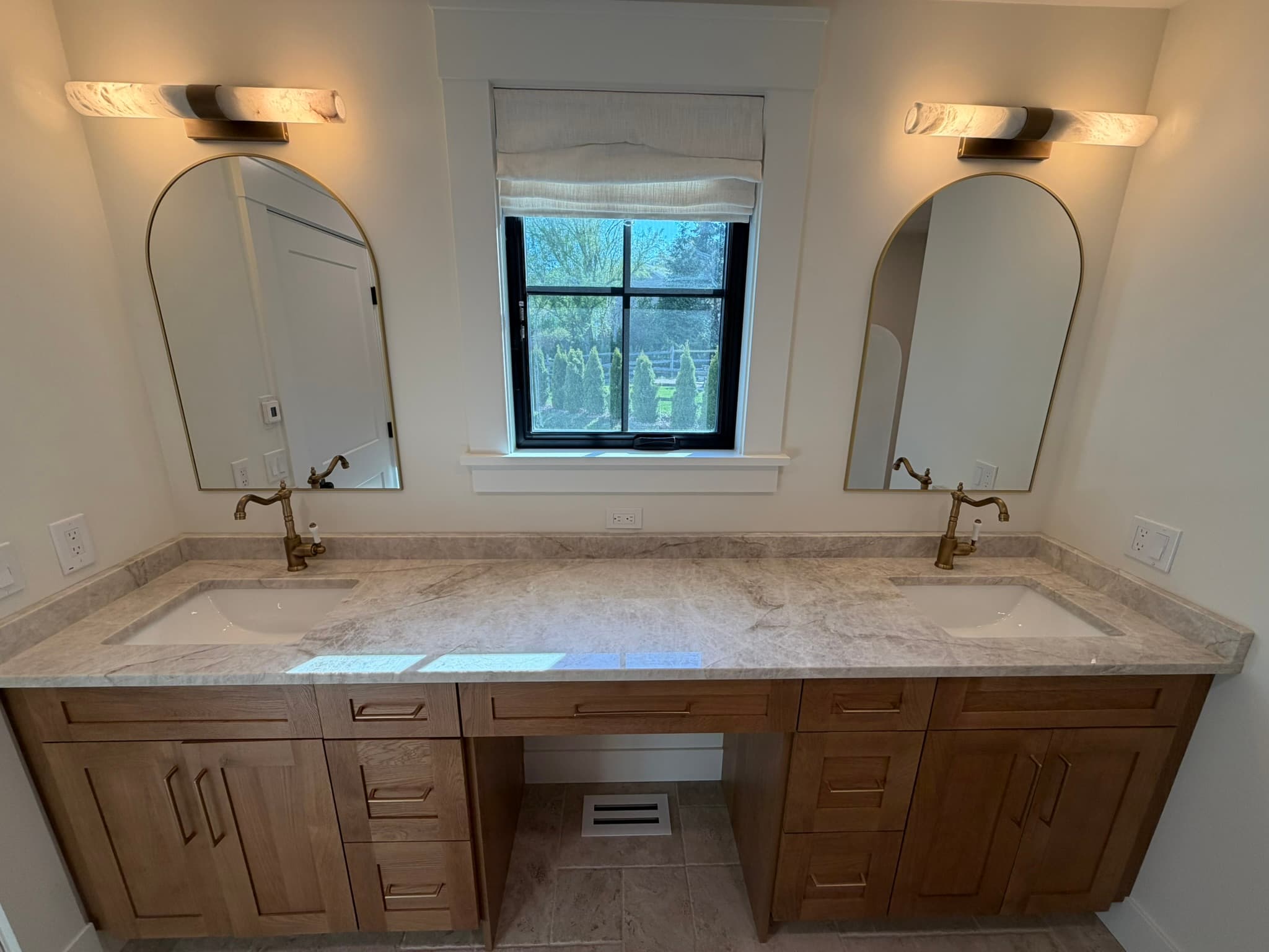 Primary bath makeup vanity and window with a marble counter