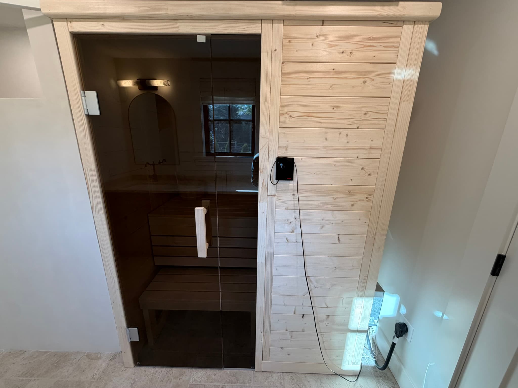 Tiled walk-in shower with a wood-clad accent wall