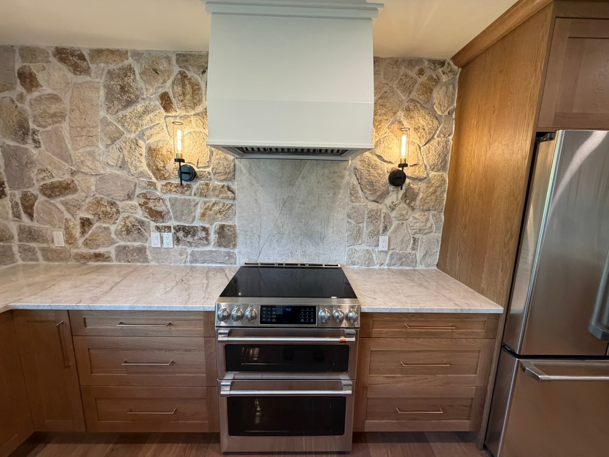 Range and stone backsplash with stainless appliances